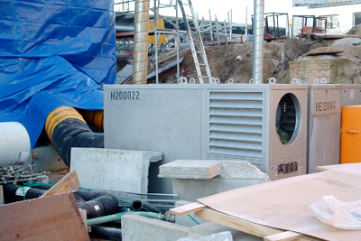 Eine mobile Warmluftheizung auf der Baustelle. Die mobilen Heizgeräte eignen sich optimal zum Trocknen von Beton und Estrich.